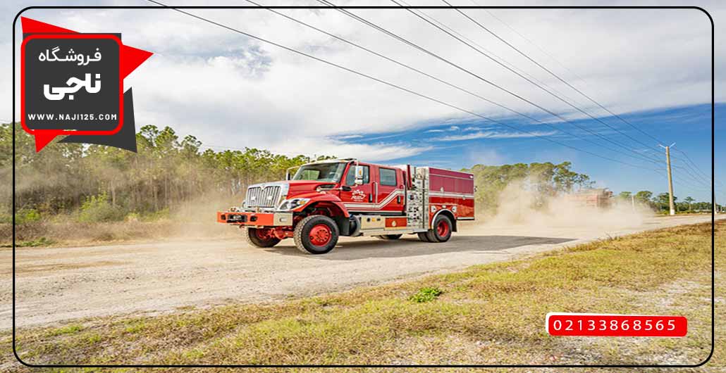 یک ماشین آتش نشانی که در جاده خاکی در حال حرکت است.